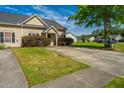 Well-maintained single-story home with lush lawn and long driveway at 1209 River Rock Rd, Hanahan, SC 29410