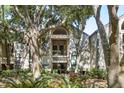 Exterior of a condo complex showcasing stairs leading to units, surrounded by lush greenery and trees at 1342 Pelican Watch Villas, Seabrook Island, SC 29455