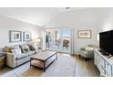 Bright living room with vaulted ceilings, sliding glass doors to a balcony, and comfortable furnishings at 1342 Pelican Watch Villas, Seabrook Island, SC 29455