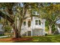Inviting two-story home featuring a classic exterior, dual porches, and mature trees draped with Spanish moss at 1409 Lieben Rd, Mount Pleasant, SC 29466