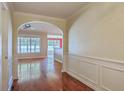Inviting entryway with hardwood floors, arched doorways, and decorative wall paneling, leading to bright, open living spaces at 1436 Harbor Mist Ct, Charleston, SC 29492