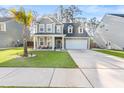Attractive two-story home with a well-maintained lawn, a palm tree, and a welcoming front porch area at 149 Caleb Ct, Ladson, SC 29456
