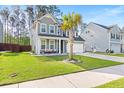 Beautiful two-story home with a lush green lawn, a palm tree, and a cozy front porch at 149 Caleb Ct, Ladson, SC 29456