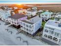 Aerial view of colorful beachfront homes with multiple balconies at sunset at 1681 E Ashley Ave # A, Folly Beach, SC 29439