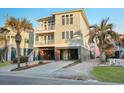 Exterior view of a beach house with a stilt foundation, driveway, and palm trees at 1681 E Ashley Ave # A, Folly Beach, SC 29439