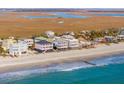 Waterfront homes line the beach in this aerial view of the scenic coastline community at 1681 E Ashley Ave # B, Folly Beach, SC 29439