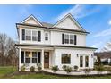 Charming two-story white home featuring black shutters, front porch, manicured landscaping, and inviting walkway at 177 Cantona Dr, Summerville, SC 29483
