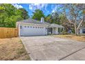 Spacious home featuring a two-car garage, concrete driveway, and mature trees, offering a blend of comfort at 1932 Staffwood Rd, Johns Island, SC 29455