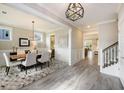 Elegant dining room with wood table, modern chandelier, gray chairs, and decorative rug at 200 Clearblue Loop, Summerville, SC 29486