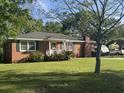 Inviting brick home with green lawn, mature trees, front porch, and traditional windows, creating a cozy curb appeal at 210 Ellen St, Goose Creek, SC 29445