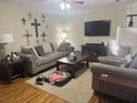 Comfortable living room featuring plush seating, hardwood floors, a large TV, and a cozy atmosphere with warm lighting at 210 Ellen St, Goose Creek, SC 29445