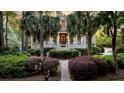 Inviting Southern-style home with a grand porch, mature landscaping, and palm trees framing the walkway at 2104 Royal Pine Dr, Seabrook Island, SC 29455