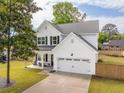 Beautiful two-story house with white siding, black shutters, a manicured lawn, and a two-car garage at 217 7Th Ave, Mount Pleasant, SC 29464