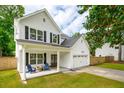 Inviting two-story house with white siding, black shutters, a front porch, and an attached two-car garage at 217 7Th Ave, Mount Pleasant, SC 29464