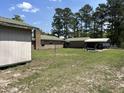View of the backyard with multiple storage sheds and open space at 240 Kerrison St, Varnville, SC 29944