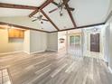 Open living room with vaulted ceiling, wooden beams, fireplace, and new luxury vinyl plank flooring at 330 Crestwood Dr, Moncks Corner, SC 29461
