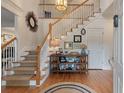 Elegant foyer features a staircase, wood flooring, and stylish decor, creating a warm and inviting entry into the home at 3424 Henrietta Hartford Rd, Mount Pleasant, SC 29466