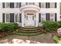 Inviting front entrance with elegant columns, a balcony, and meticulously landscaped steps, creating a warm and welcoming ambiance at 3424 Henrietta Hartford Rd, Mount Pleasant, SC 29466