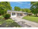 Inviting brick home with crisp white trim, black shutters, and a concrete driveway leading up to the entrance at 4432 Logwood Drive, Ladson, SC 29456