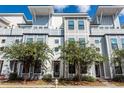 Modern townhome featuring light gray siding, dark trim windows and landscaping at 4577 Summey St, North Charleston, SC 29405