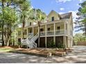 Two-story home featuring a welcoming porch, white railings and ample space for outdoor relaxation at 478 Commonwealth Rd, Mount Pleasant, SC 29466