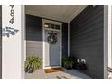 Inviting front porch with a wreath, potted plants, and a 'Welcome Home' doormat at 484 Trotters Ln, Moncks Corner, SC 29461