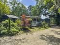 Charming home nestled amongst lush greenery, showcasing a long porch and tranquil setting at 4869 Slans Island Rd, Hollywood, SC 29449