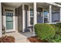Welcoming front porch with classic white columns, views of the garden, and a stylish front door at 5049 Song Sparrow Way, Summerville, SC 29483