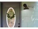 Close-up of a gray front door with an oval window and a decorative wreath at 5452 E Lakeland Dr, North Charleston, SC 29406