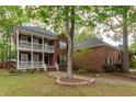 Charming two-story brick home featuring a double porch, black shutters, and manicured front lawn at 5496 Clearview Dr, North Charleston, SC 29420