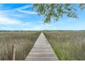 Picturesque walkway through a marsh leading to a peaceful gazebo at 5703 St Angela Dr, North Charleston, SC 29418