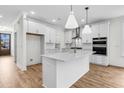 Modern white kitchen featuring a central island, stainless steel appliances, and sleek cabinetry, offering a contemporary design at 739 Maynard Ln, Summerville, SC 29486