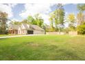 View of home featuring a spacious yard, attached garage, and rear fencing to provide privacy and seclusion at 74 Longleaf Dr, Walterboro, SC 29488
