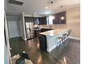 Modern kitchen with granite countertops, stainless steel appliances, and dark cabinets at 7406 Purser Ln, Hanahan, SC 29410