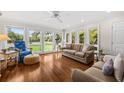 Sunlit living room with hardwood floors and large windows offering views of a well-maintained lawn at 754 Summerwind Cir, Edisto Island, SC 29438