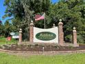 Community entrance sign with an American flag and manicured landscape at 8551 Pope Landing Rd, Edisto Island, SC 29438