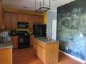 Functional kitchen with wooden cabinets, black appliances, and a central island at 9163 Parlor Dr, Ladson, SC 29456