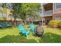 Lush backyard with Adirondack chairs, fire pit, and view of neighboring homes at 9316 Sweetbay Ct, Ladson, SC 29456