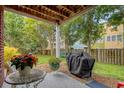 Cozy covered patio featuring a table, grill, and view of the lush backyard at 9316 Sweetbay Ct, Ladson, SC 29456