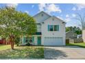 Inviting two-story home featuring a spacious porch with rocking chairs and well-maintained landscaping at 1005 Golden Aspen Dr, Moncks Corner, SC 29461