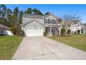 Inviting two-story home with gray siding, a well-kept lawn, and a driveway leading to a white garage door at 1019 Victoria Pointe Ln, Summerville, SC 29485
