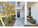 Inviting front porch with dark front door, bench seating, lush landscaping, and a beautiful view beyond at 108 O'Leary Cir, Summerville, SC 29483