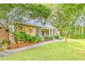 Landscaped front yard leading to a cozy home with stone and siding details and a lovely garden at 111 Garden Hill Rd, Summerville, SC 29483