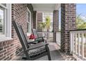Cozy front porch with rocking chairs, brick columns, and a view of the neighborhood at 112 Brailsford St, Charleston, SC 29492