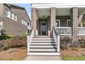 Inviting front porch with brick columns, a wooden staircase, and a visible house number at 112 Brailsford St, Charleston, SC 29492