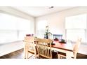 Bright dining room with wood floors, a wooden table, and lots of natural light from the large windows at 115 E East Sunrise Lane, Summerville, SC 29486