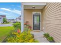 Inviting front porch with stylish decor, featuring a black door, and vibrant landscaping at 134 Stoney Creek Way, Moncks Corner, SC 29461