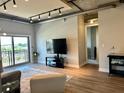 Open living area with exposed ductwork, industrial lighting, and sliding doors opening to outdoor views at 150 Bee St # 611, Charleston, SC 29401