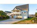Charming two-story home with a ground-level garage and upper balcony overlooking a waterfront at 1614 Teal Marsh Rd, Charleston, SC 29412