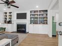 Inviting living room with custom built-ins, a decorative fireplace, ceiling fan, and hardwood floors at 1637 Pinckney Park Dr, Charleston, SC 29407